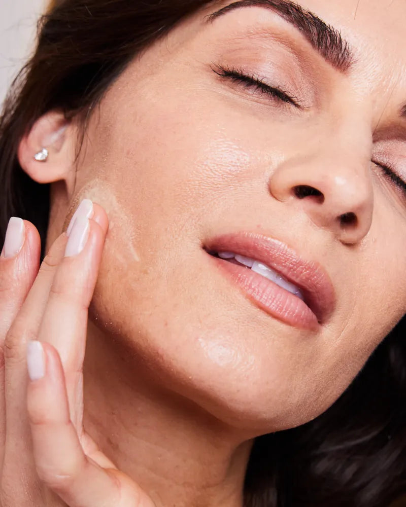 Woman with radiant skin applying RXR Retinol Anti-Aging Serum by Dr. S